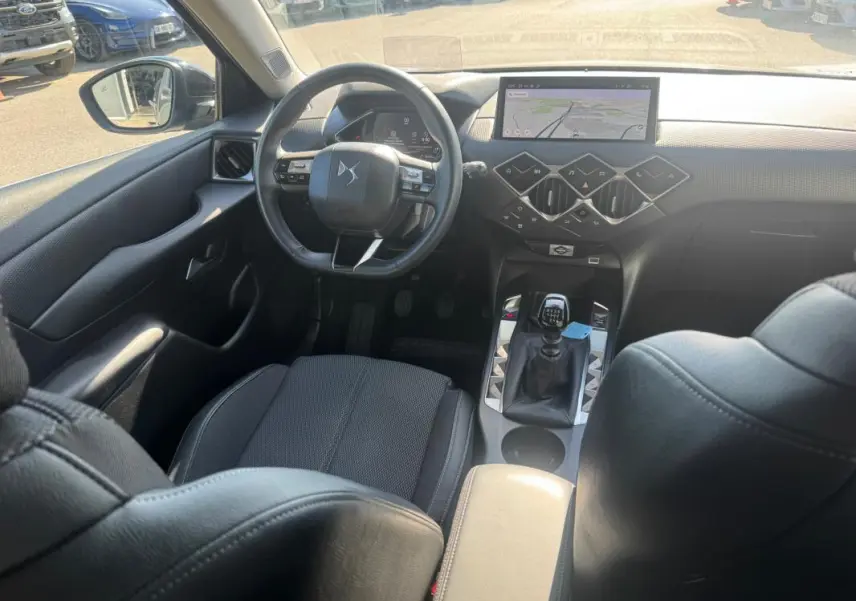 Vue intérieure côté conducteur du DS3 100 BVM6 Bastille 2024, volant multifonction et levier de vitesses manuel visibles.
