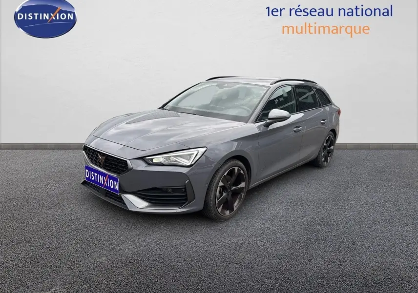 Vue 3/4 avant droite d'une CUPRA LEON ST gris Graphene avec jantes noires et calandre distinctive.