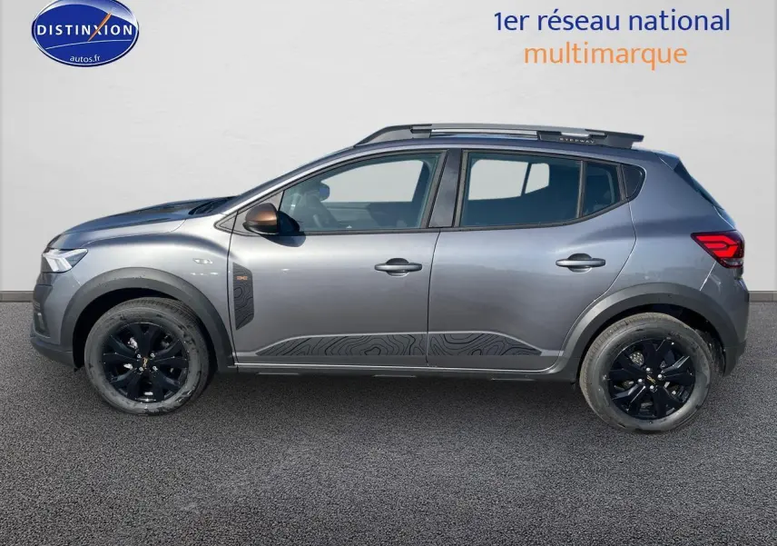 Profil côté gauche de la Dacia Sandero Stepway gris schiste avec jantes noires et barres de toit visibles