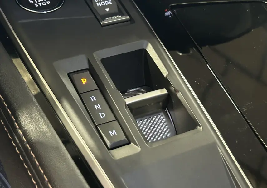 Gros plan sur la console centrale de la Peugeot 508 SW 2024, montrant la commande de boîte auto et le bouton Drive Mode.