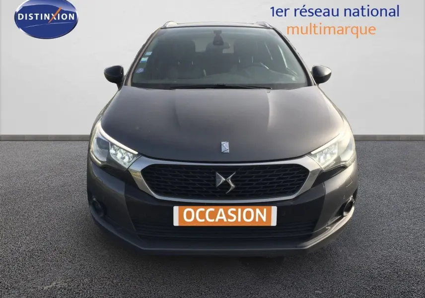 Vue frontale d'une DS4 CROSSBACK gris platinium métal avec calandre hexagonale et phares LED allumés.
