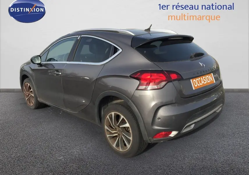 Vue 3/4 arrière droite d'une DS4 CROSSBACK gris platinium métallisé avec jantes bi-ton et feux LED distinctifs.