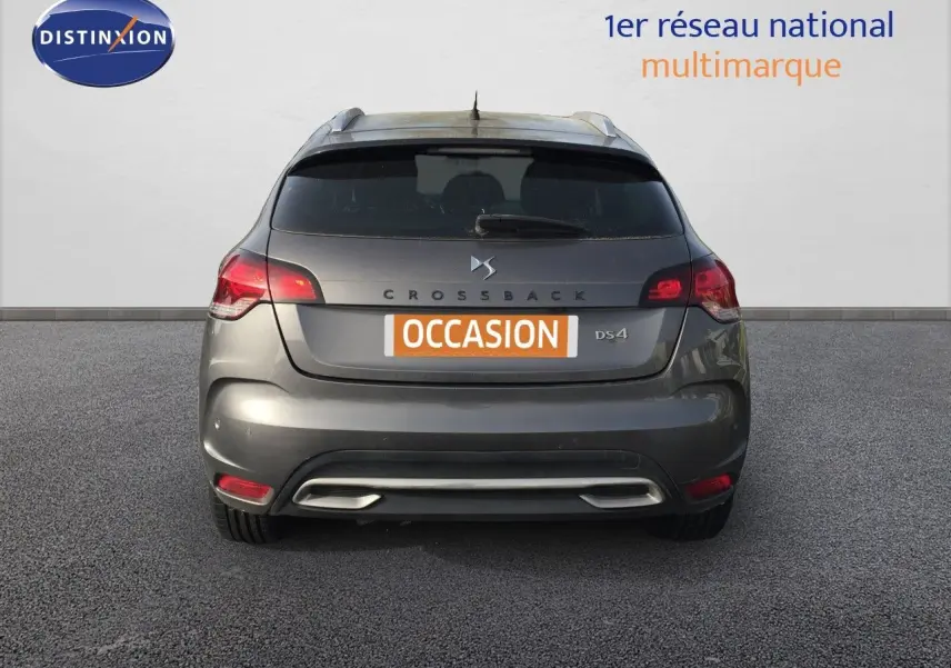 Vue arrière d'un DS4 CROSSBACK gris platinium métal avec feux rouges et plaque "OCCASION" visible.
