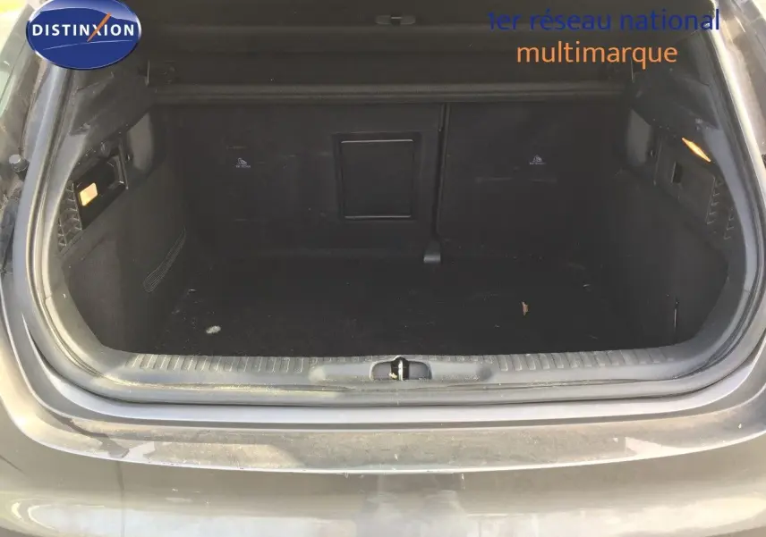 Coffre ouvert vu de l'arrière d'un DS4 CROSSBACK gris platinium métal, espace de chargement vide et propre.