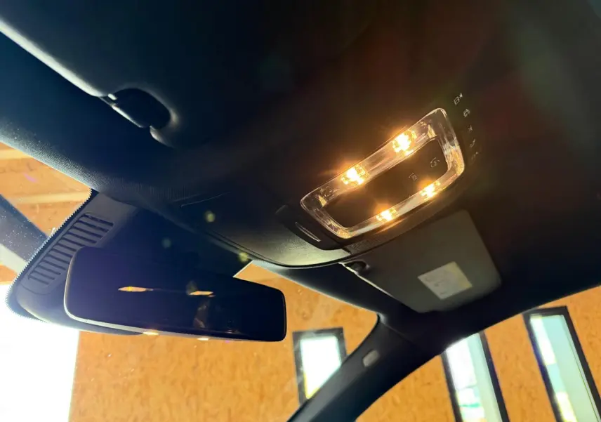 Vue intérieure du plafonnier et du rétroviseur intérieur d’une Mercedes Classe A 220D AMG Line de 2019 avec toit noir.