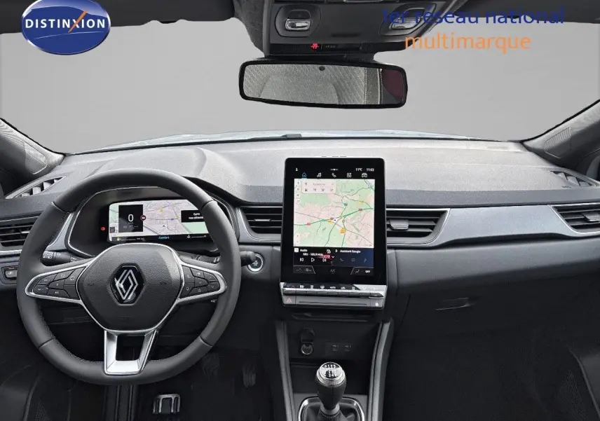 Vue intérieure avant du Renault Captur II hybride 2025, tableau de bord gris avec écran tactile central et volant multifonction.