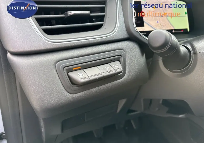 Vue intérieure côté conducteur du tableau de bord du Renault Captur gris Rafale, avec commandes d'assistance et écran de navigation.