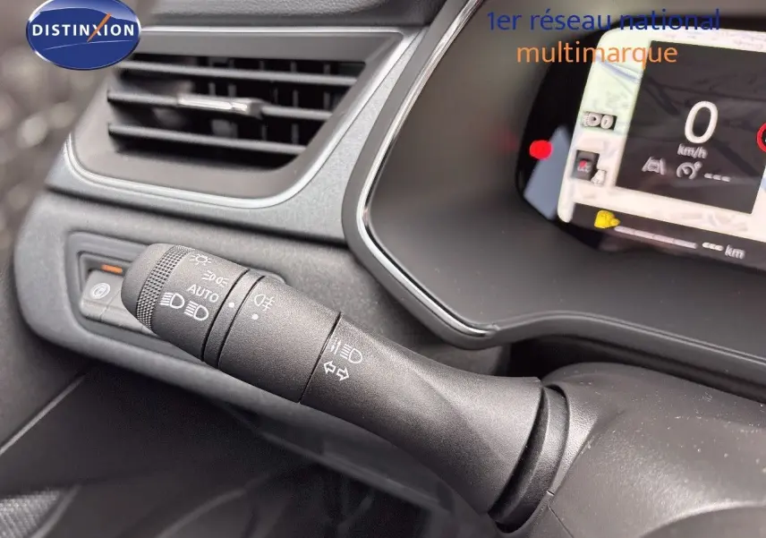 Gros plan sur la commande des feux et clignotants à gauche du volant dans l’habitacle gris noir du Renault Captur 2025.
