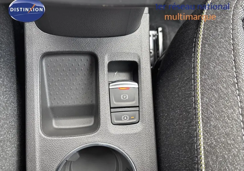 Vue rapprochée de la console centrale du Renault Captur gris rafale métal, avec commandes de frein à main électronique et tissu noir.