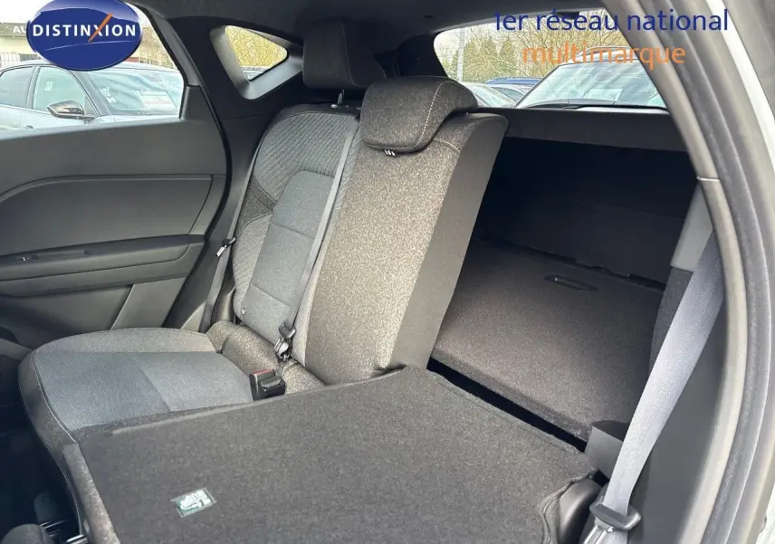 Vue intérieure arrière côté droit du Renault Captur II gris rafale métal, siège rabattable et banquette tissu gris.