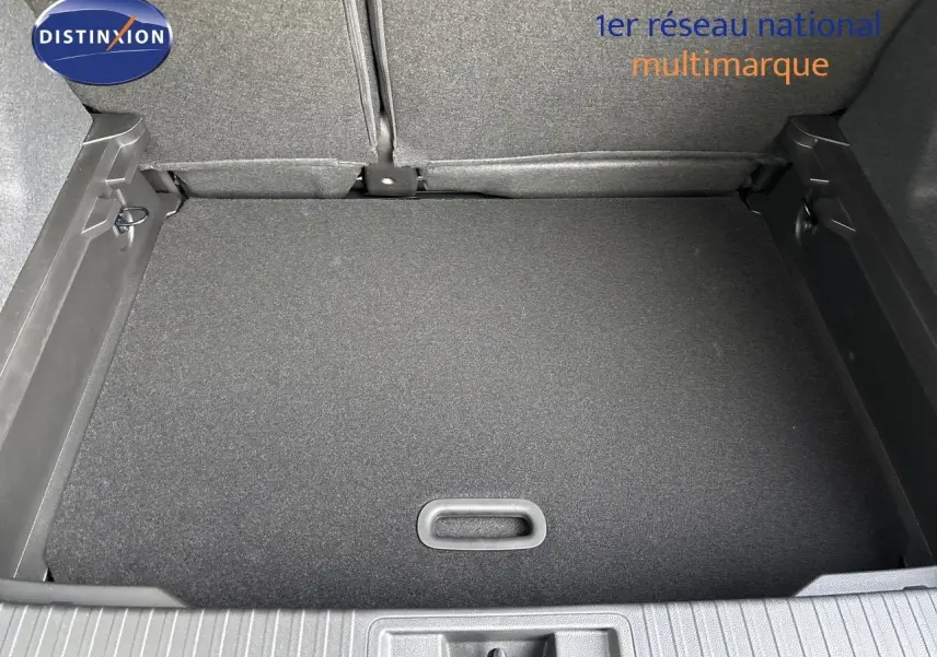 Vue plongeante sur le coffre spacieux et propre du Renault Captur II hybride 2025, avec revêtement noir uniforme.