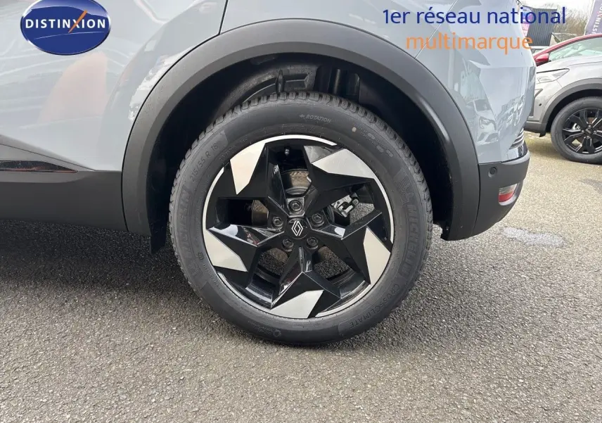 Gros plan sur la roue arrière droite du Renault Captur II gris Rafale métal avec jante noire et argentée au design étoilé.