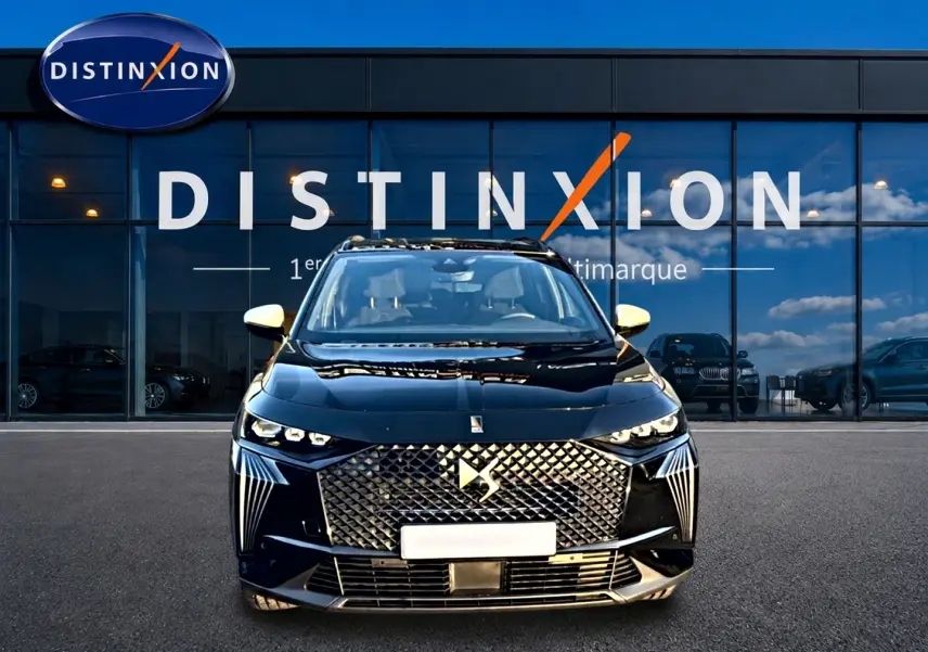 Vue frontale d'un DS7 noir 2026 avec calandre distinctive et phares LED, devant une vitrine Distinxion.