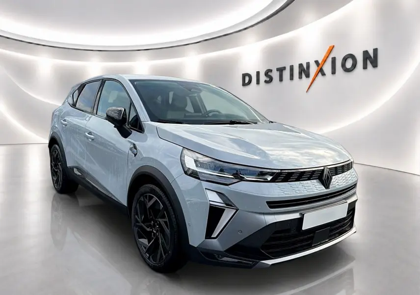 Renault Symbioz gris rafale en 3/4 avant droit, avec jantes noires et calandre moderne dans un showroom lumineux.