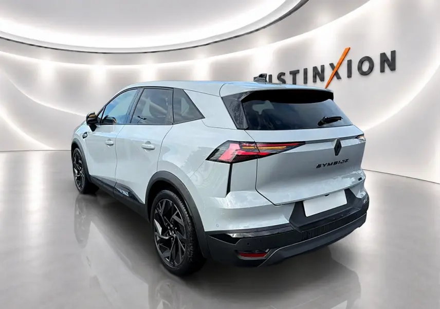 Vue 3/4 arrière droite du Renault Symbioz gris rafale avec feux arrière LED et jantes noires en showroom.