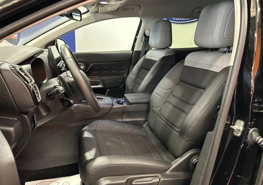 Vue intérieure côté conducteur du Citroën C5 Aircross noir Perla Nera, sièges cuir noir et tableau de bord moderne.