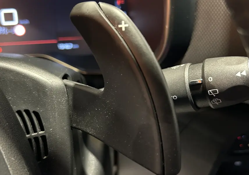 Gros plan sur la palette de changement de vitesse droite du volant du Citroën C5 Aircross noir Perla Nera, avec commandes au volant visibles.