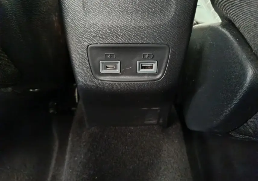 Prise USB type C et USB standard sur la console centrale arrière d'une Peugeot 208 gris clair 2025.