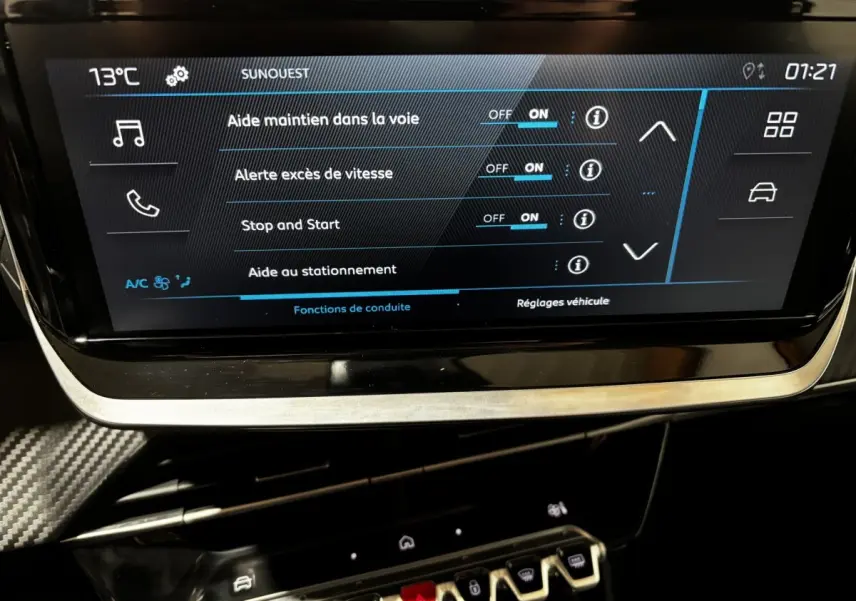 Écran tactile central de la Peugeot 208 Hybrid 110, affichant les réglages d’aide à la conduite, intérieur noir.