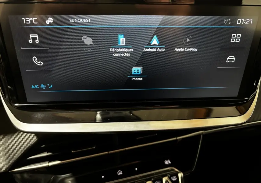 Écran tactile central affichant les options Apple CarPlay et Android Auto dans une Peugeot 208 jaune hybride.
