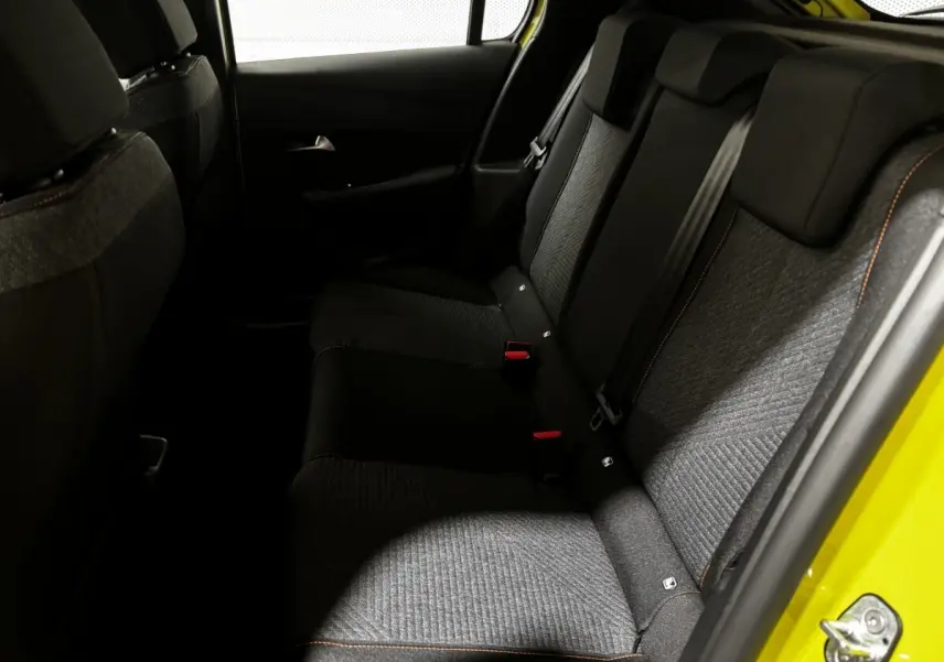 Vue intérieure côté droit des sièges arrière gris et noirs d'une Peugeot 208 jaune 2025 hybride.