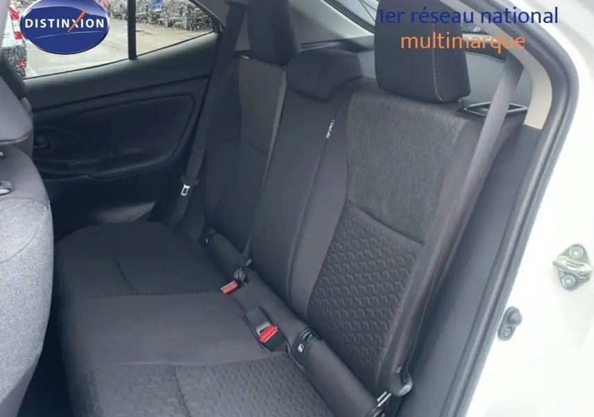 Vue intérieure côté droit sur les sièges arrière en tissu gris et noir d'une Toyota Yaris Cross Hybrid blanche 2024.