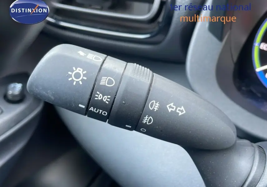 Gros plan sur la commande des phares et clignotants dans l'habitacle de la Toyota Yaris Cross Hybrid blanche 2024.