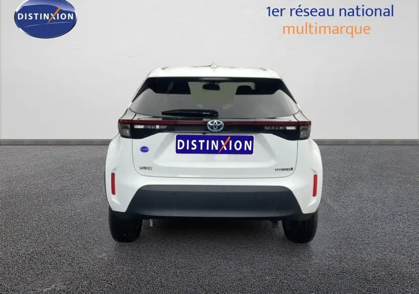 Vue arrière d'une Toyota Yaris Cross Hybrid blanche 2024 avec hayon noir et feux arrière horizontaux.