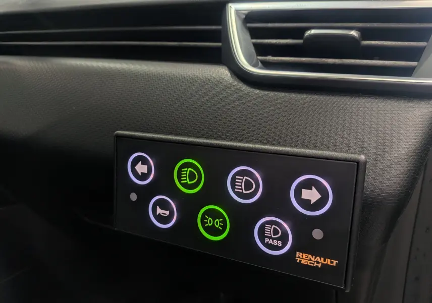 Panneau de commandes lumineux intérieur avec boutons de feux et clignotants sur Renault Clio V Gris Platine, vue rapprochée.