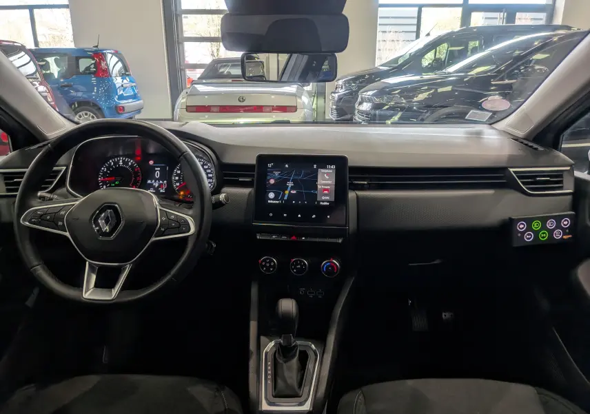 Vue intérieure avant de la Renault Clio V Gris Platine 2021, avec tableau de bord et écran tactile central visible.