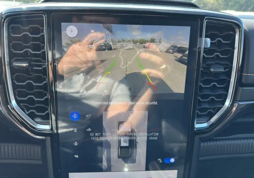 Écran tactile central affichant la caméra de recul avec lignes de guidage dans un Ford Ranger blanc 2026.