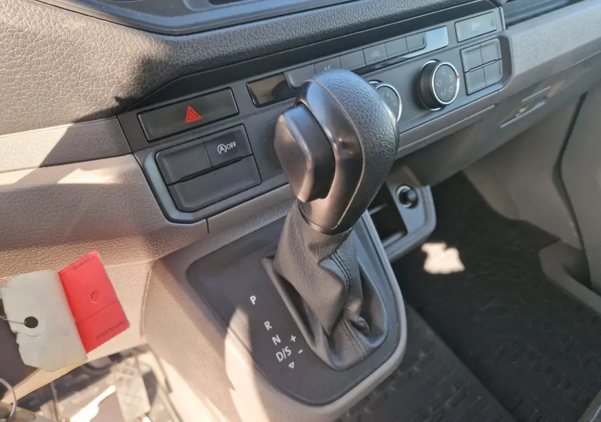 Gros plan sur le levier de vitesse automatique noir dans l'habitacle gris clair du Volkswagen Crafter blanc de 2021.