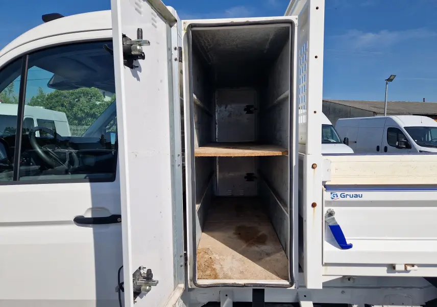 Vue latérale gauche d’un Volkswagen Crafter blanc 2021 avec coffre ouvert et benne arrière visible.