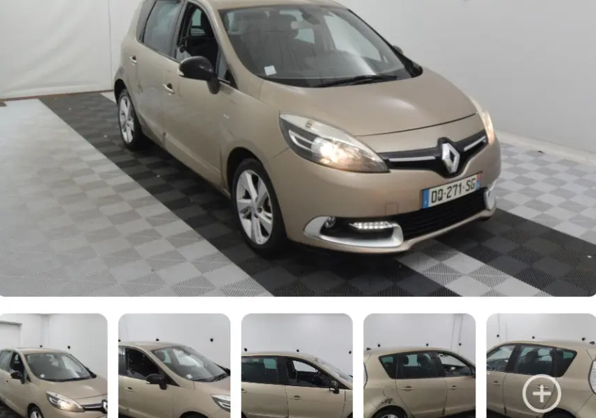 Renault Scénic III beige vue 3/4 avant droit avec phares allumés et jantes aluminium dans un studio blanc.