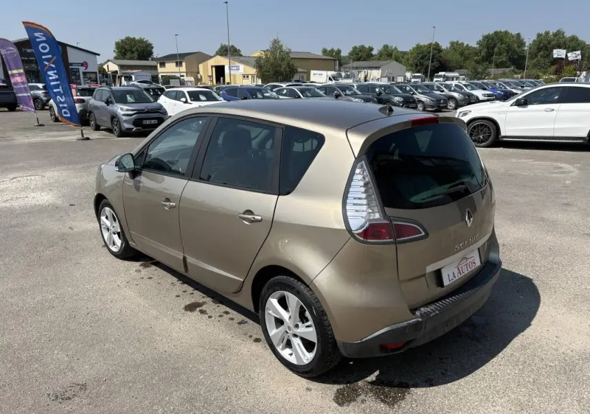 Renault Scénic III beige vue 3/4 arrière droit, vitres surteintées et jantes aluminium visibles en extérieur.