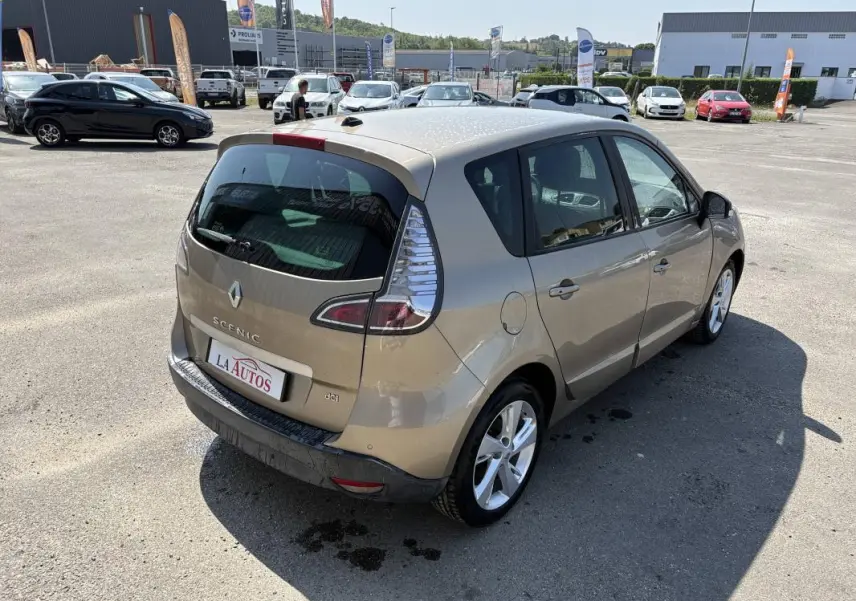 Renault Scénic III beige vue 3/4 arrière droit, vitres surteintées et jantes aluminium visibles en extérieur.
