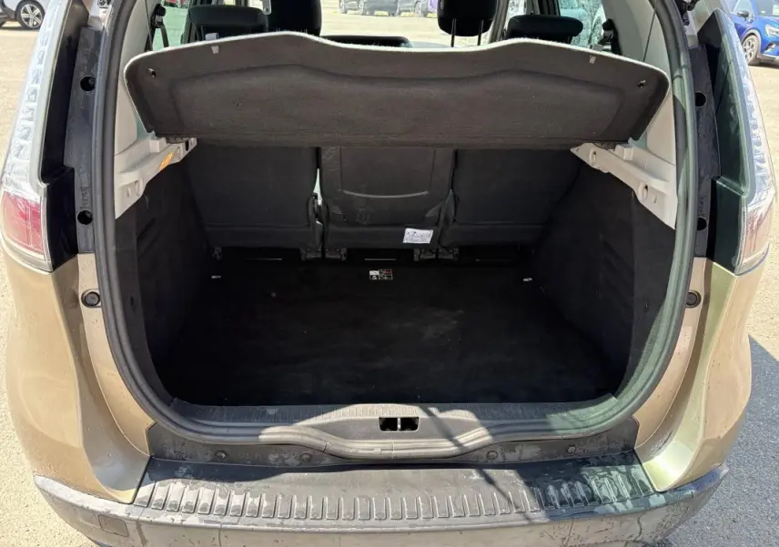 Vue arrière ouverte du coffre beige du Renault Scénic III 2015, montrant l'espace de chargement vide et la tablette cache-bagages.