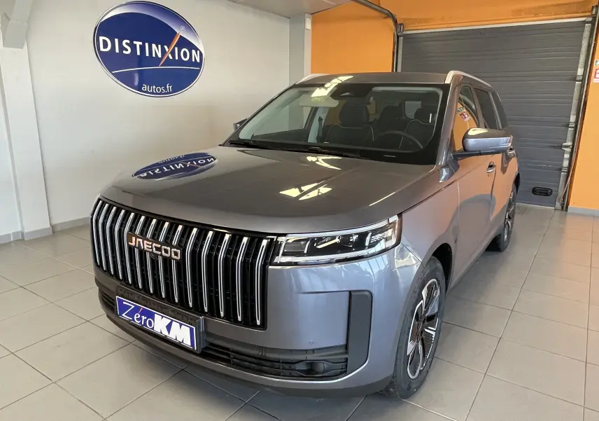 Vue 3/4 avant du JAECOO J5 gris Phantom avec calandre verticale chromée et jantes stylisées en concession.
