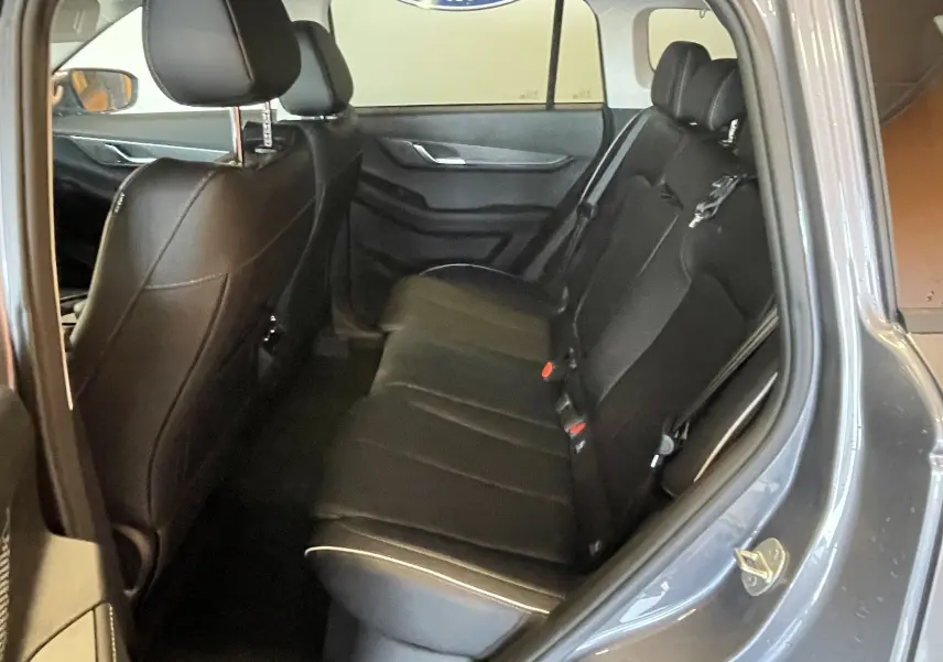 Vue intérieure arrière côté droit du JAECOO J5 2026 en Phantom Grey Metal, sièges cuir noirs avec surpiqûres claires.