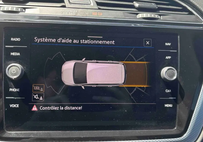 Écran tactile du système d'aide au stationnement du Volkswagen Touran 2025 affichant une vue top-down du véhicule.