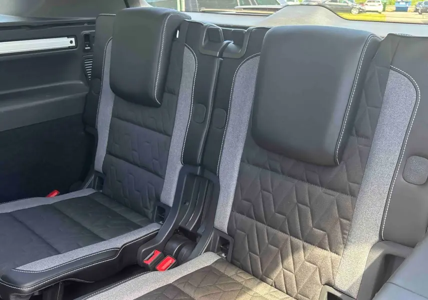 Vue rapprochée des sièges arrière en tissu noir et gris du Volkswagen Touran 2025, version 7 places.