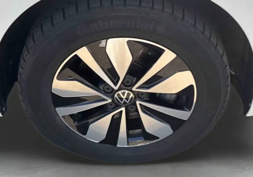 Gros plan sur la jante alliage bicolore du côté avant droit d’un Volkswagen Touran blanc.