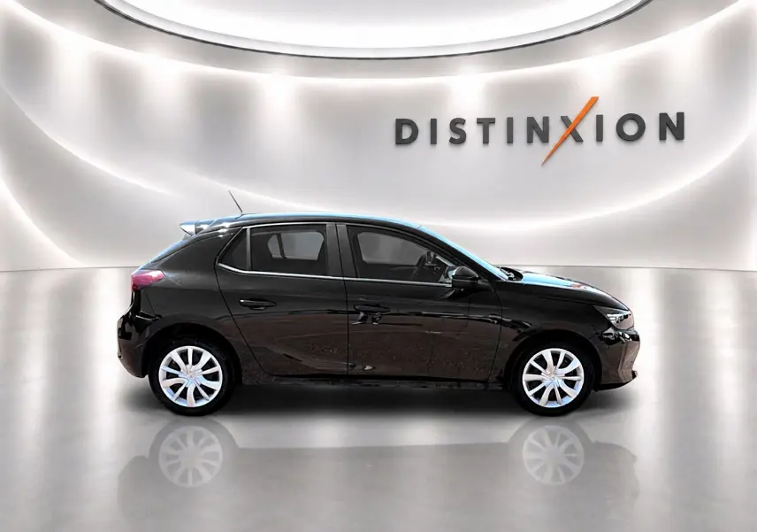 Profil droit d'une Opel Corsa noire 2025 dans un showroom lumineux avec logo Distinxion en arrière-plan.