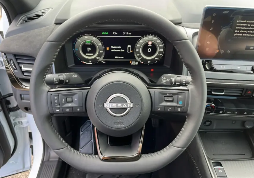 Vue centrée sur le volant cuir multifonctions noir du Nissan Qashqai E-POWER 2026 avec tableau de bord numérique et écran tactile.