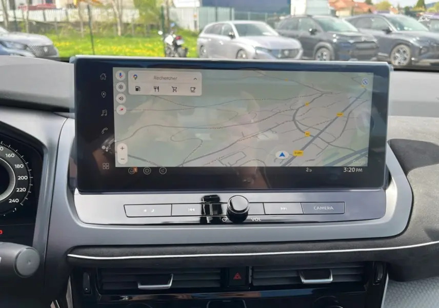Vue rapprochée de l’écran tactile central du tableau de bord du Nissan Qashqai blanc nacré 2026 avec navigation GPS affichée.