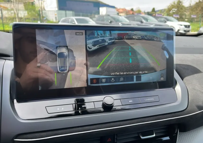 Écran central affichant la caméra 360° et la vue arrière du Nissan Qashqai blanc nacré avec toit noir.
