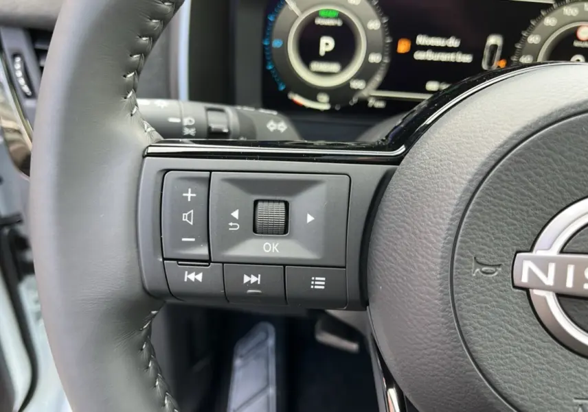 Gros plan sur le volant cuir multifonctions gris du Nissan Qashqai E-POWER 2026 avec commandes intégrées.