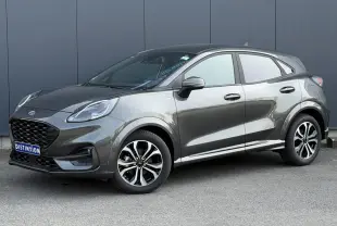 Ford Puma Ecoboost 155 ST Line gris magnétique en 3/4 avant droit, avec jantes alliage et calandre noire distinctive.