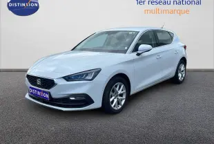 Vue 3/4 avant d'une SEAT Leon 2025 blanc neige métal avec jantes alliage et calandre noire distinctive.