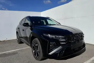 Hyundai Tucson IV noir abyss métal en 3/4 avant droit, avec calandre N Line et jantes alliage 19 pouces.